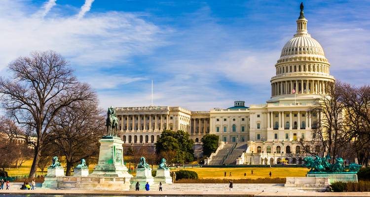 Le bâtiment du Capitole américain avec les sculptures environnantes et les piétons.
