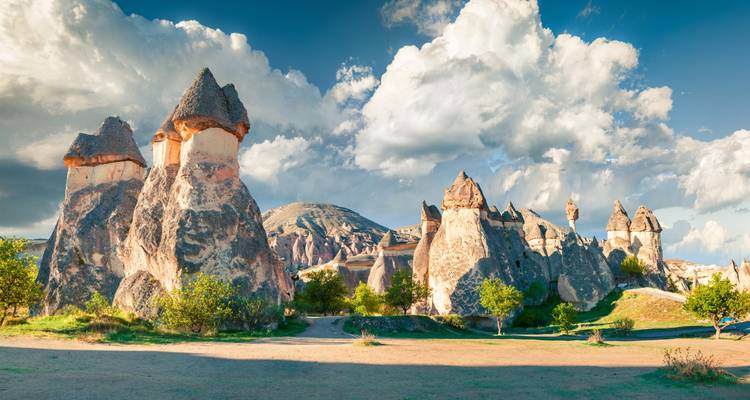 Iconic fairy-chimney rock formations under a dramatic cloud-filled sky in Cappadocia.