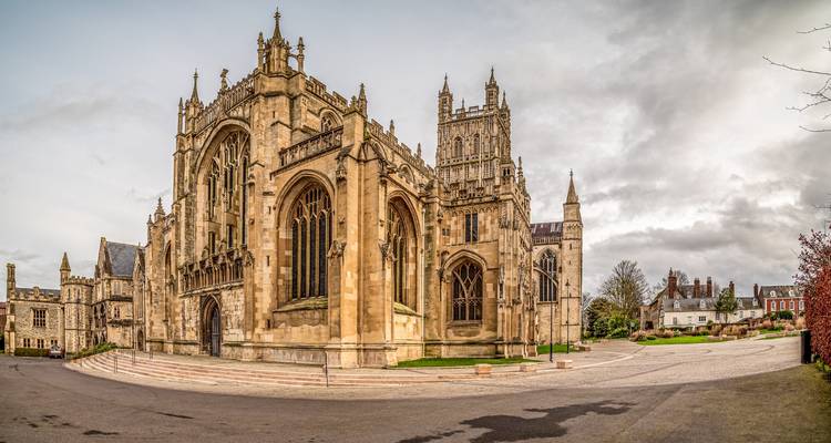 Panoramic view of stately Gloucester Cathedral under soft cloudy sky.