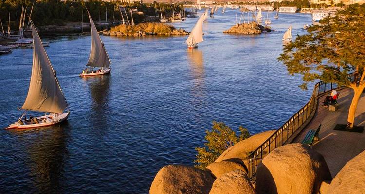 Vista del río con veleros y un paseo panorámico.