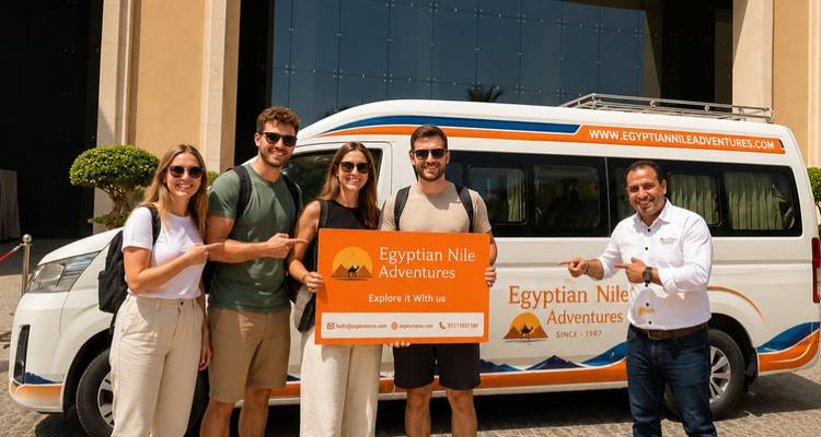 Groupe d'amis et un guide posant avec un véhicule de tournée à l'extérieur, tenant une pancarte Egyptian Nile Adventures.