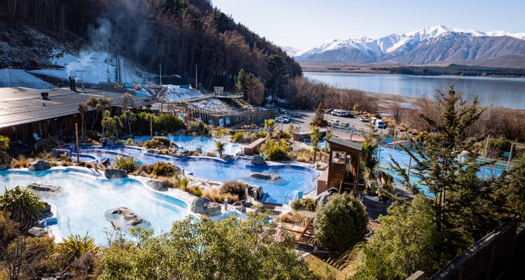Belle scène au bord du lac avec des piscines et des montagnes en arrière-plan.