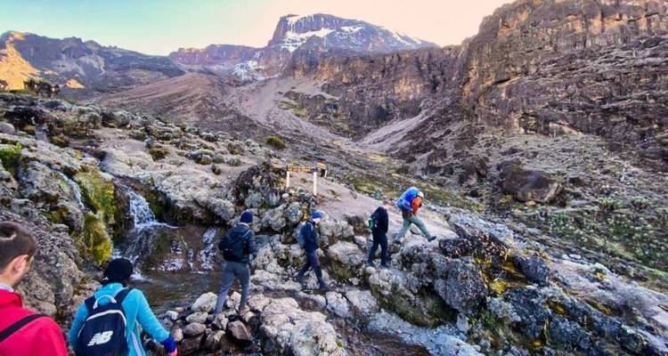 Des randonneurs naviguant sur un terrain rocheux avec vue sur la montagne.