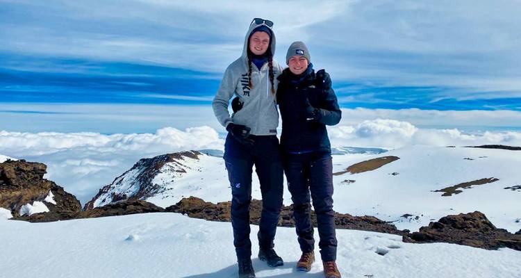 Deux personnes debout sur une montagne enneigée