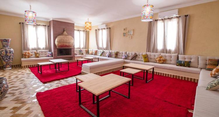 Espace de vie spacieux avec des tapis rouges, des canapés et des tables.