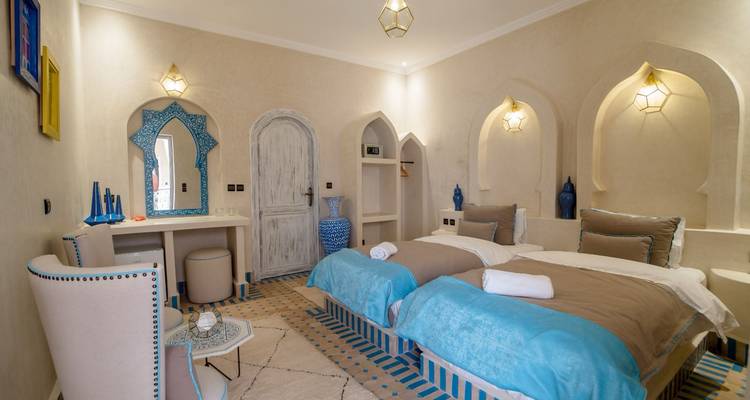 Chambre d'hôtel avec deux lits, décorée avec goût.