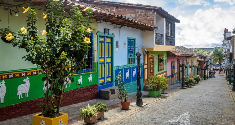 Rue colorée dans une ville avec des façades de maisons peintes.