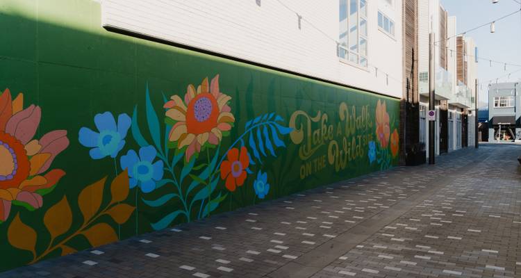 Fresque colorée sur un mur dans un cadre urbain moderne.