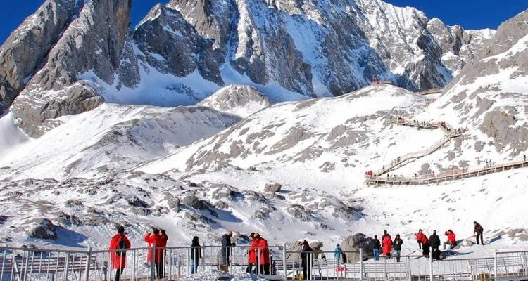 Des gens en vestes rouges explorant des montagnes enneigées.