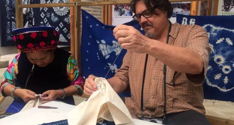 Deux personnes engagées dans une activité de teinture traditionnelle de tissu.