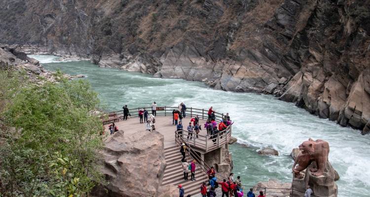 Touristes à un point de vue panoramique sur une gorge de rivière.
