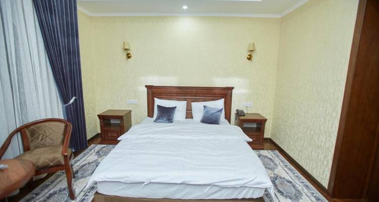 Ein gemütliches Hotelzimmer mit zwei Betten und warmer Beleuchtung.