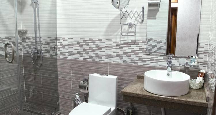 Un baño limpio y moderno con ducha y puertas de cristal.