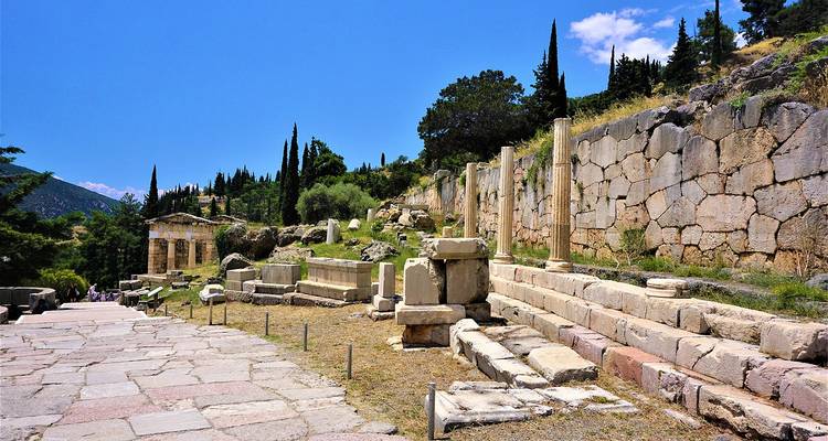Ruines de pierre et bâtiments anciens sous un ciel bleu dégagé.