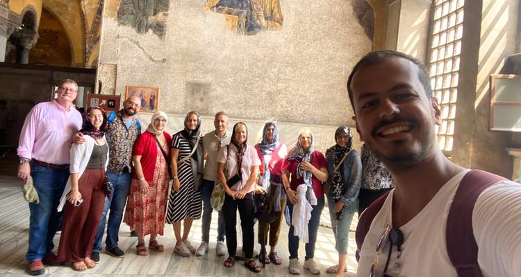 Group of people posing inside a historical building.