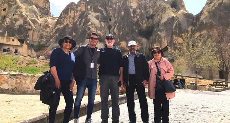 Group of people standing in front of a rocky landscape.