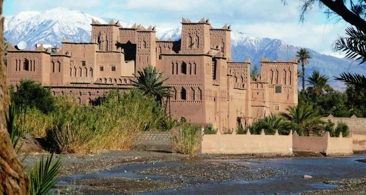 Traditionelle Wüstenfestung mit Bergen im Hintergrund.