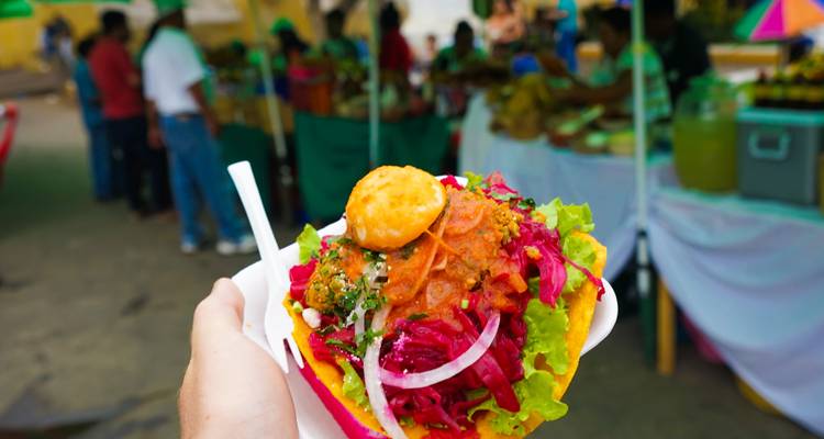 Main tenant un plat coloré et vibrant sur un marché.