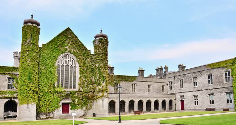 Bâtiment historique recouvert de lierre dans un campus universitaire.
