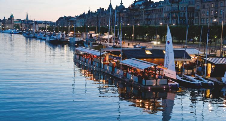 Des bateaux alignés le long d'une promenade au bord de l'eau au crépuscule.