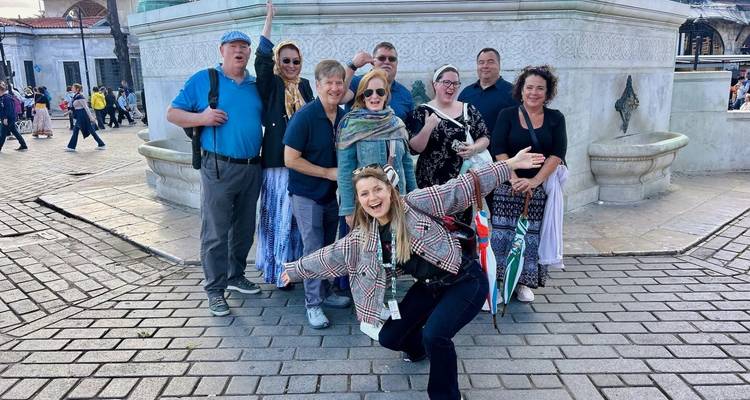 Groupe de personnes posant sur une place de ville.