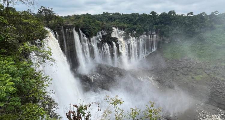 Puissante cascade à plusieurs niveaux qui dévale une falaise luxuriante de forêt tropicale entourée de brume et de verdure.