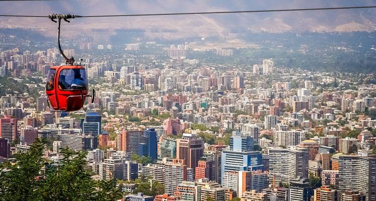 Un téléphérique passe au-dessus d'un paysage urbain avec de nombreux bâtiments en arrière-plan.