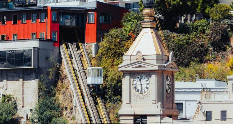 Un ancien funiculaire avec une horloge de tour sur une colline.