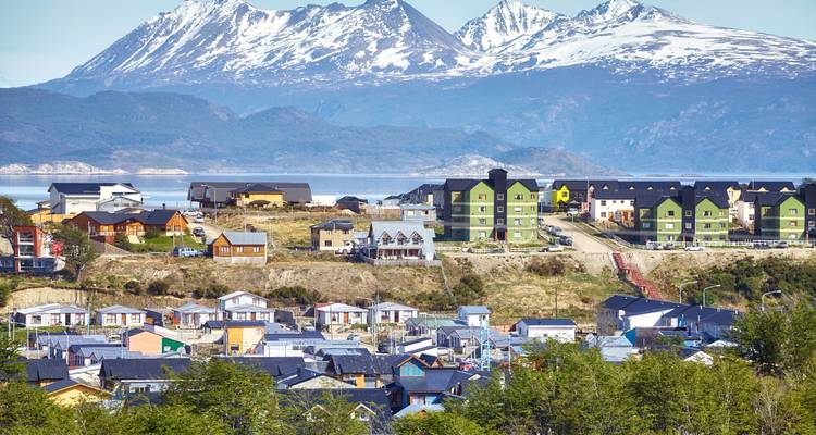 Maisons colorées dans une ville avec un paysage montagneux en arrière-plan.