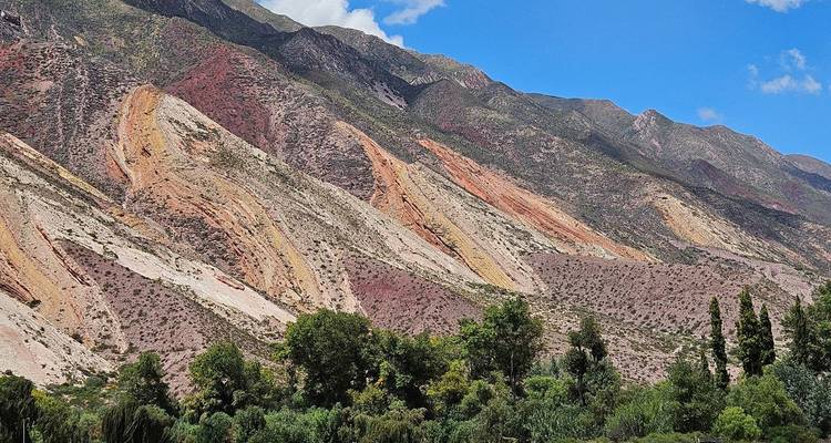 Montagnes multicolores vibrantes sous un ciel bleu.