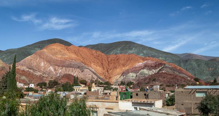 Une ville avec des chaînes de montagnes vibrantes en arrière-plan.
