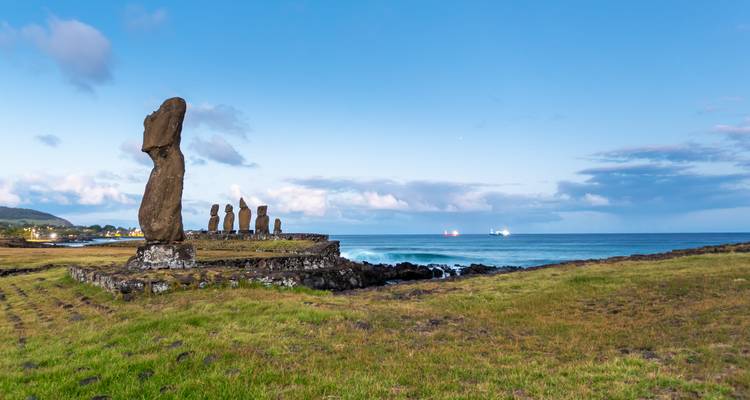 Vista lateral de las estatuas Moai en la costa con el océano de fondo.