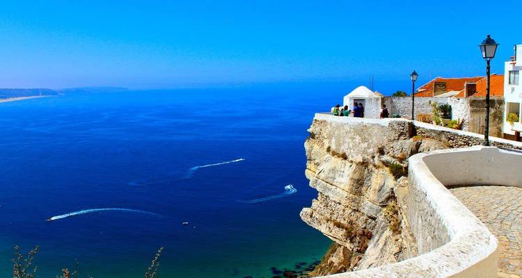 Dramatischer Klippenweg mit Blick auf den tiefblauen Atlantischen Ozean an einem strahlend sonnigen Tag.