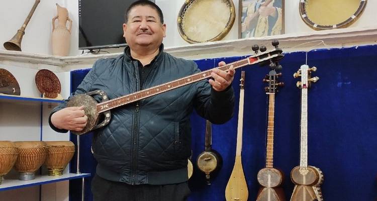 Un homme dans un magasin de musique tenant un instrument traditionnel