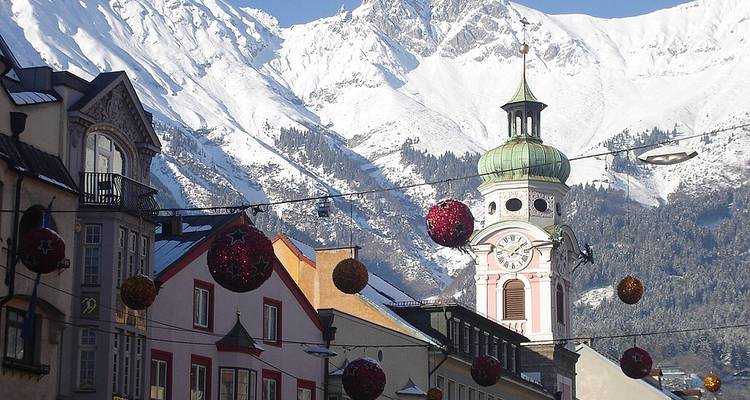 Une tour d'horloge avec des montagnes enneigées en arrière-plan