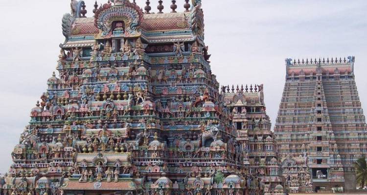 Torre de templo colorida con esculturas intrincadas y cielo azul.