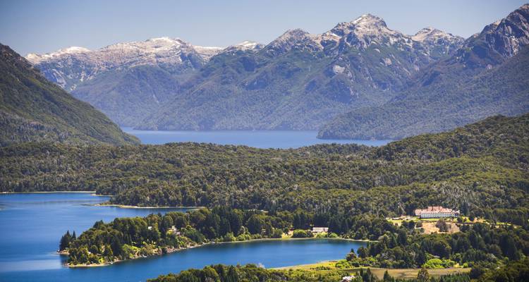 Une vue pittoresque d'un lac entouré de forêts luxuriantes et de chaînes de montagnes.