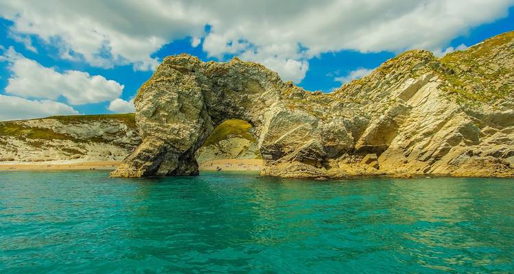 Arche rocheuse naturelle avec mer turquoise calme.