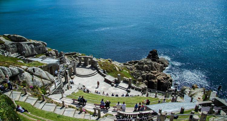 Amphithéâtre extérieur au bord de la mer avec des personnes assises.