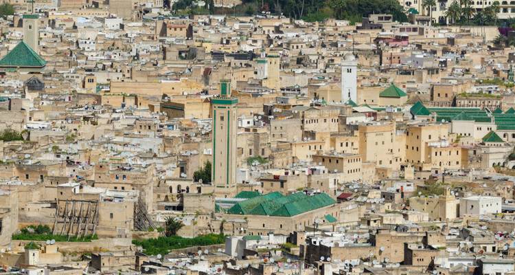 Luftaufnahme von Fes mit dicht gedrängten Gebäuden und sichtbaren Minaretten.