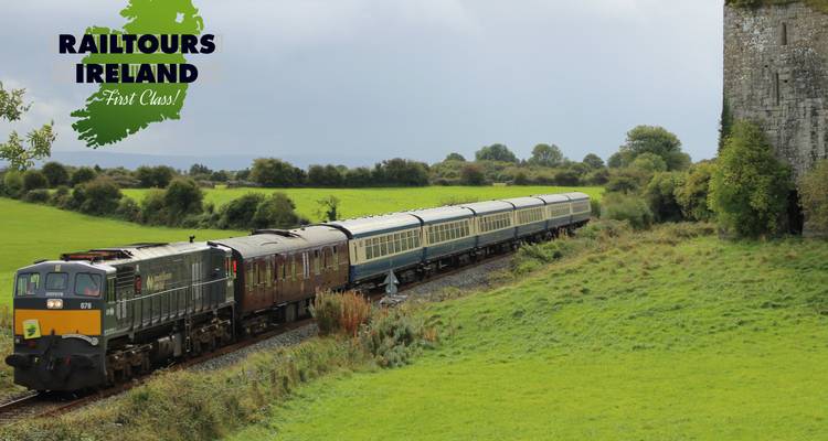 Un train se déplaçant à travers un paysage verdoyant avec un filigrane dans le coin supérieur gauche.