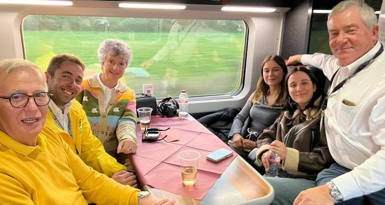 Groupe de personnes assises qui savourent des boissons à l'intérieur d'un train.