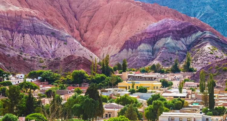 Kleurrijke heuvels en een dorp aan de voet van de heuvels.