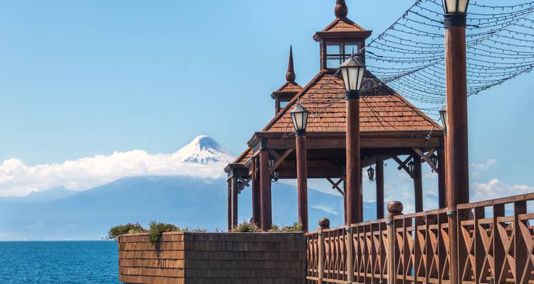 Structure en bois avec vue sur un volcan enneigé.