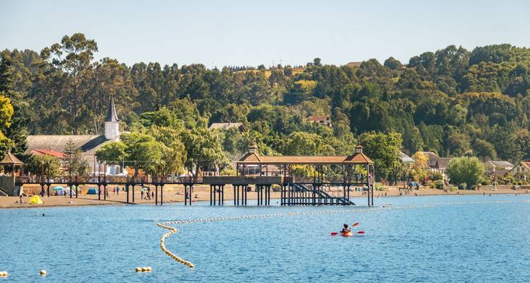Bord de mer avec des gens et une jetée visible.