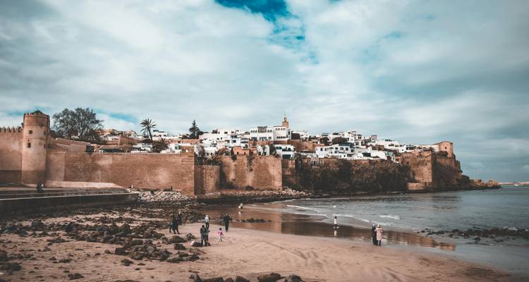 Frente de playa en Rabat con familias y fortificaciones.