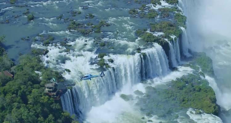 Vista aérea de las Cataratas del Iguazú con un helicóptero cerca.