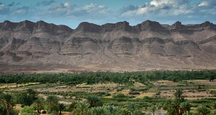 Paisaje montañoso con valle verde exuberante abajo.