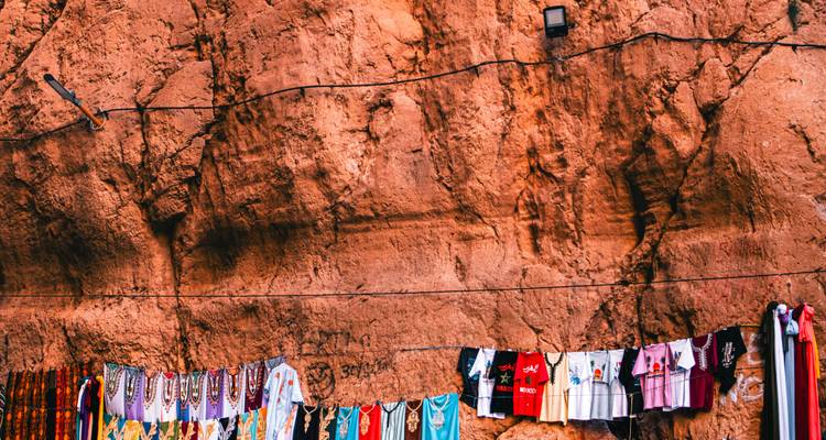 Ropa colorida colgando contra un fondo rocoso.