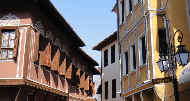 Bâtiments traditionnels avec des façades colorées et des détails ornés sous un ciel bleu clair.